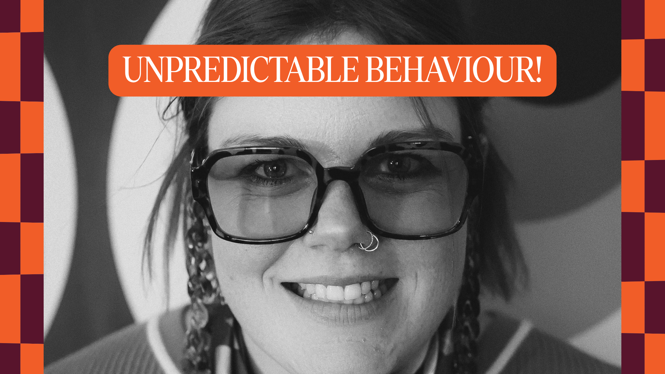 Shay's face smiles unnervingly into the camera wearing sunglasses. With an orange warning message saying "Unpredictable Behaviour"